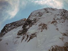 
Close up of the Broad Peak Central Summit and the Broad Peak Main Summit just after sunrise from Concordia.
The first ascent of Broad Peak was completed by Marcus Schmuck, Fritz Wintersteller, Kurt Diemberger, and Hermann Buhl on June 9, 1957. This extremely small expedition marked a major step forward in the development of Himalayan climbing. Diemberger: �[Buhl's] plan was that from base camp onwards there would only be climbers on the mountain; they would do everything, load-carrying, establishment of camps and, finally, the assault on the summit. And it was all to be done without the use of oxygen.� Diemberger reached the summit just as Marcus Schmuck and Fritz Wintersteller started their descent. As Diemberger was descending from the summit he met Buhl still ascending. �Slowly, with all that incredible strength of his will, he started to move, very slowly, upwards. ... Two men were standing on a peak, still breathing heavily from the ascent, their limbs weary - but they did not notice it; for the all-enveloping glory of the sun's low light had encompassed them too. Deeper and deeper grew the colours. ... No dream-picture, this. It was real enough, and it happened on the 26,404-foot summit of Broad Peak.� � Summits And Secrets by Kurt Diemberger.
